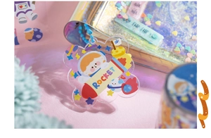 Macro detail of a flower-shaped acrylic keychain featuring a cartoon astronaut and rocket