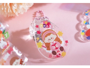 Detailed macro view of a teardrop acrylic keychain with cartoon girl and pink chain