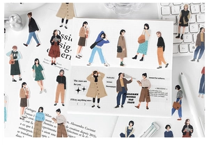 Detailed close-up of girls' street fashion stickers on a white grid notebook page