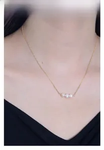 Detailed view of 925 silver necklace with three freshwater pearls on a female model