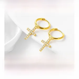 Detail of gold S925 silver hoop earrings with shimmering cubic zirconia cross charms