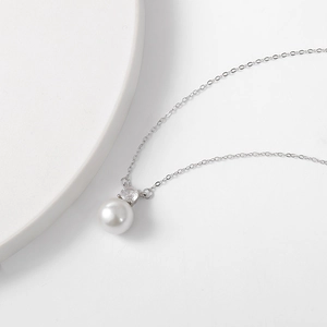Close-up of elegant S925 silver necklace with round white pearl and zircon stone