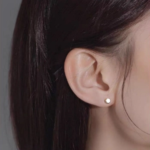 Minimalist gold S925 sterling silver hexagon stud earring worn on the earlobe