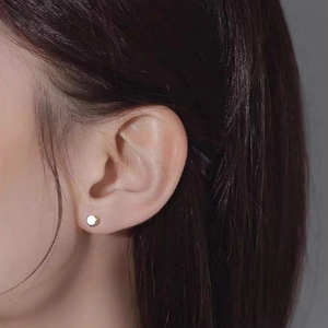 Minimalist S925 silver golden hexagonal stud earring shown on a model's ear