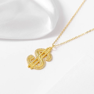 Gros plan du collier avec pendentif signe dollar en or et cristaux scintillants pavés