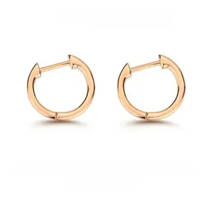 Détail de boucles d'oreilles créoles minimalistes en argent 925 plaqué or poli