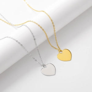 Vue macro de pendentifs cœur minimalistes en or et argent sur chaînes fines