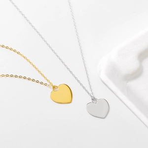 Vue détaillée de pendentifs en cœur or et argent sur chaînes fines au design épuré