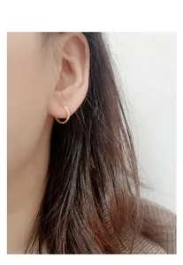 Détail de la boucle d'oreille créole en argent 925 plaqué or portée sur l'oreille