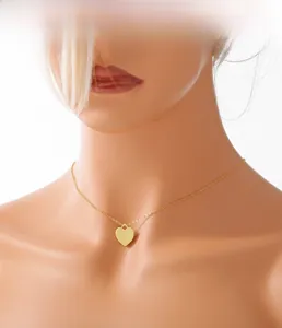 Détail d'un collier pendentif cœur doré sur un mannequin pour visualiser le rendu porté