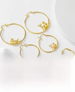 Détail de trois paires de créoles en argent 925 doré avec reliefs de Cupidon