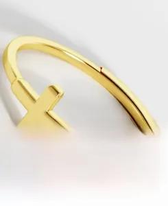 Close-up of a 925 sterling silver gold plated open ring with a simple cross design detail