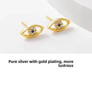 Détail macro de boucles d'oreilles œil porte-bonheur en argent sterling plaqué or
