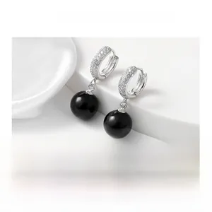 Détail de boucles d'oreilles en argent S925 avec zircons pavés et perles d'agate noire