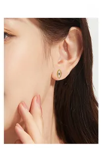 Vue détaillée d'une boucle d'oreille œil en argent S925 avec saphir bleu et zircones
