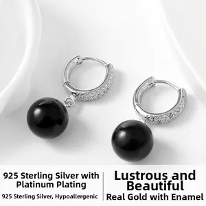 Détail de boucles d'oreilles en argent 925 avec zircons blancs et perle d'agate noire