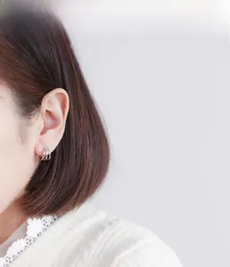 Gros plan de boucles d'oreilles géométriques à trois anneaux en argent minimaliste