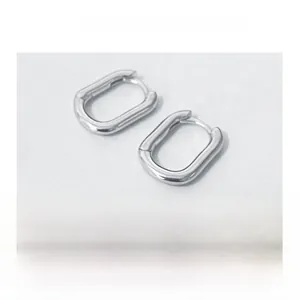 Detail of silver geometric U-shaped earrings with a polished minimalist metal finish