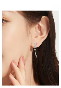 Close-up of sparkling zircon shooting star earrings worn by a model for a stylish look