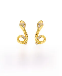 Detail of snake-shaped gold silver earrings with sparkling white cubic zirconia stones