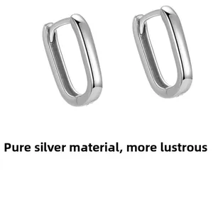 Gros plan de créoles géométriques en argent sterling poli en forme de U sur fond blanc