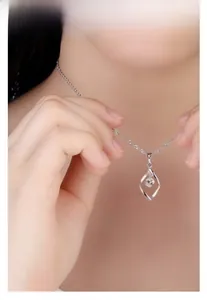Silver necklace with a twisted rhombus pendant and zircon worn on a woman's neck