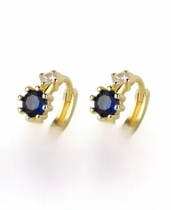 Détail des boucles d'oreilles en argent S925 doré avec pierres bleues et petits diamants