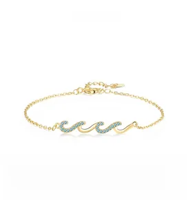 Close-up of golden wave-shaped bracelet links inlaid with sparkling sky blue stones