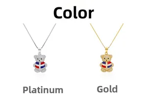 Détail du collier pendentif ourson serti de cristaux avec motif de drapeau en or et argent