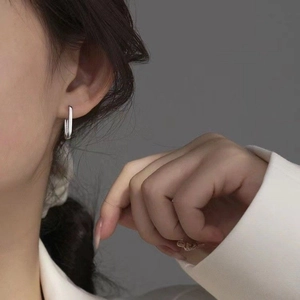 Boucles d'oreilles créoles ovales géométriques en argent 925 portées par un mannequin