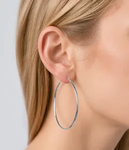 Primer plano de aros grandes de plata de ley usados por modelo con diseño minimalista