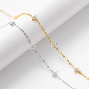 Dettaglio delle collane a quadrifoglio in oro e argento con petali di zircone