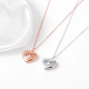 Nahaufnahme von Herzanhängern aus Silber und Roségold mit funkelnden Zirkonia-Steinen