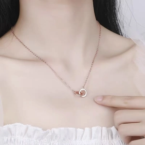 Rose gold interlocking double ring necklace with cubic zirconia on a female model