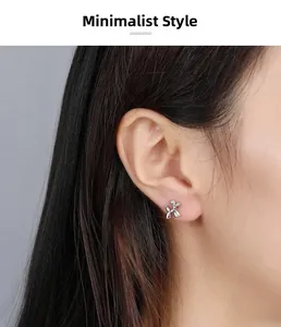 Detail of 925 sterling silver balloon dog stud earrings shown on model's ear