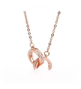 Detail of rose gold double interlocking rings necklace with shimmering pavé zircon stones
