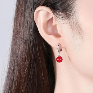 Close-up of S925 silver hoop earring with red agate bead on female model's ear
