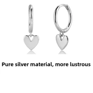 Macro detail of high-polished sterling silver heart pendants and hoop earring clasps