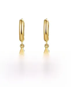 Detailed view of gold star dangle earrings with polished hoop closure for women