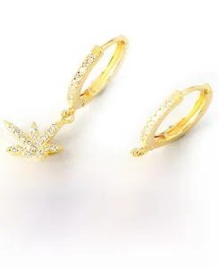 Detailed close-up of gold star earrings with sparkling cubic zirconia on white backdrop