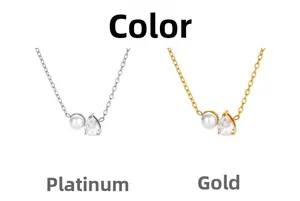Detail view of pear-cut zircon and shell pearl pendant in gold and white gold finishes
