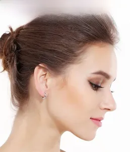 Close-up of minimalist S925 sterling silver hoop earrings worn by a model on white background