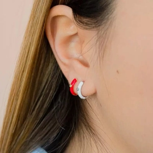 Minimalist red and white enamel hoop earrings with zircon accents worn by model