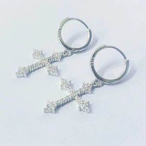 Macro shot of S925 sterling silver hoop earrings with cubic zirconia paved cross charms