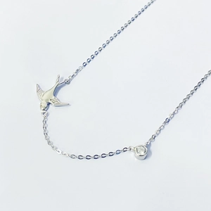 Gros plan du collier pendentif hirondelle en argent avec zircon cubique brillant