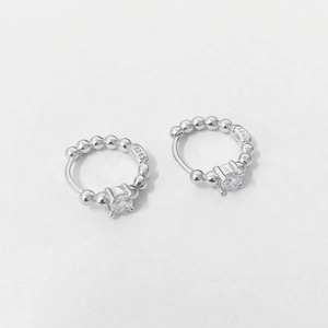 Macro shot of S925 sterling silver beaded hoop earrings with a clear zircon stone