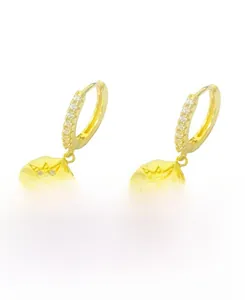 Detailed macro of gold plated S925 silver hoop earrings with micro-set star pendants