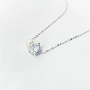 Macro view of S925 silver necklace with white pearl and pear-cut zircon stone pendant