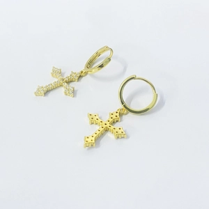 Macro shot of gold-plated cross earrings with shimmering zircon pavé and vintage detailing