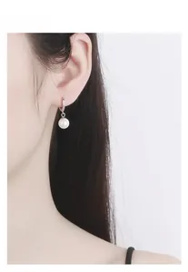 Close-up of S925 sterling silver pearl hoop earrings with zircon on a female model